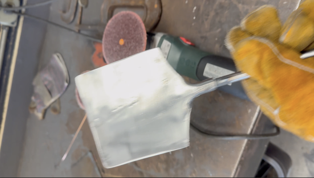 Boy wearing gloves welding a metal spatula